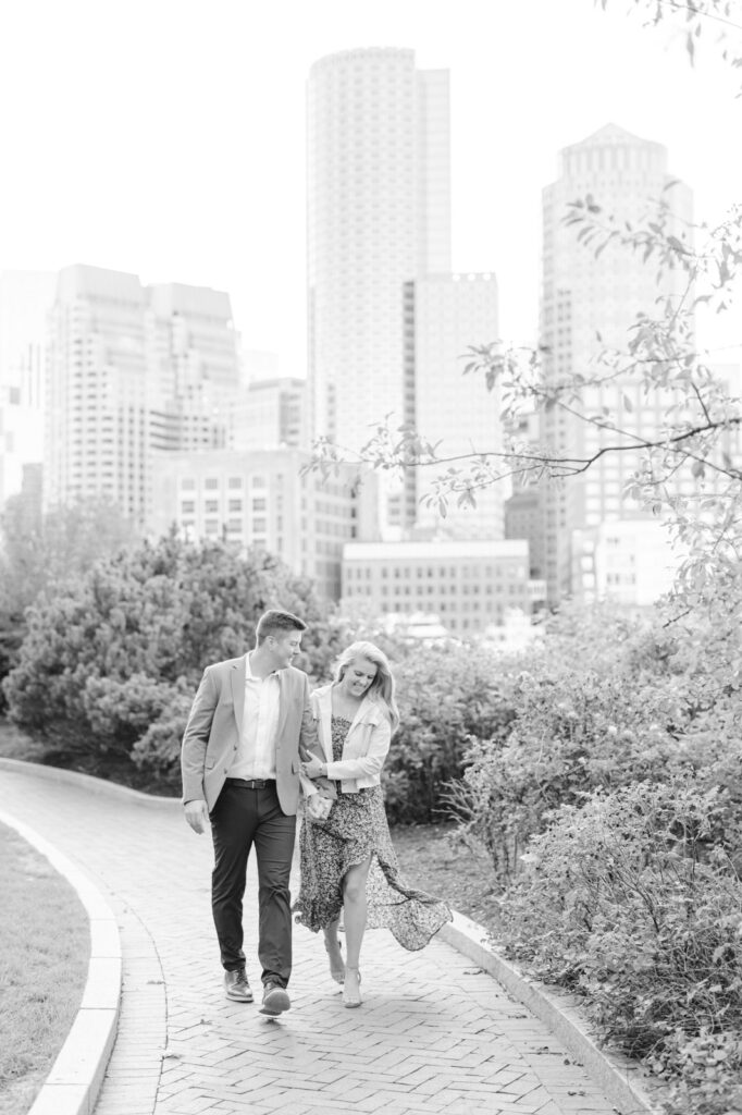 couple walking with the boston skyline behind