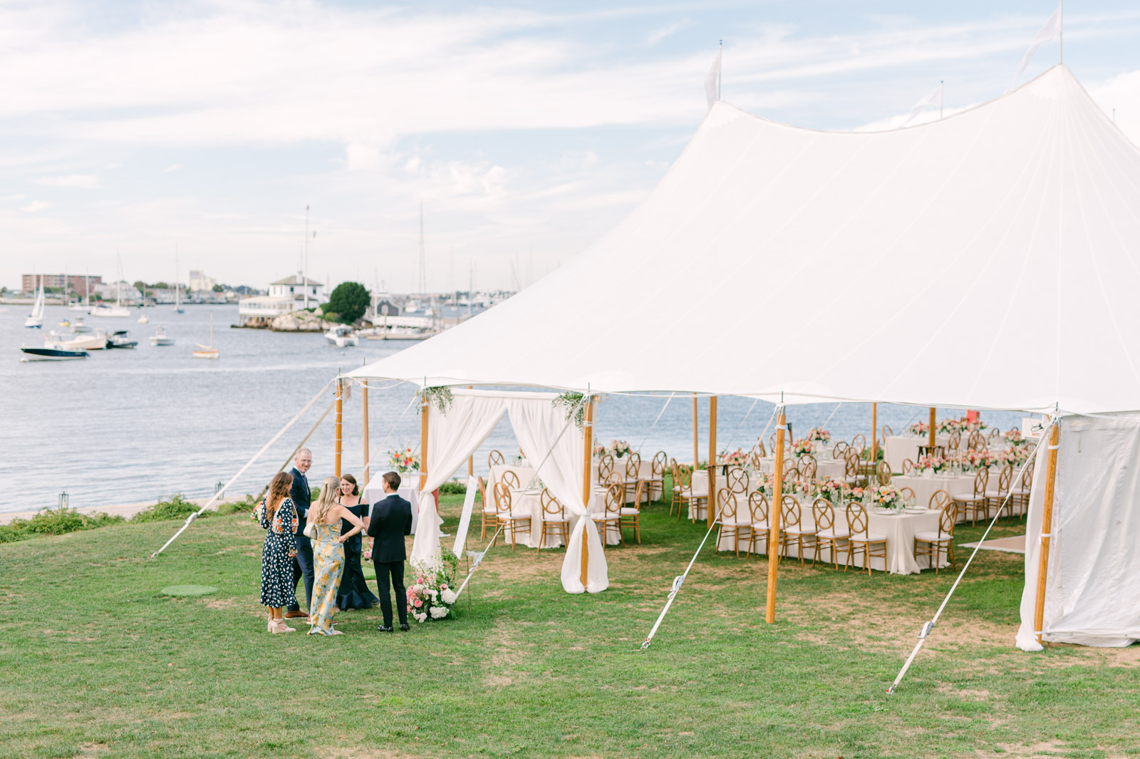 outdoor tented wedding at the new york yacht club with guests gathered around the eating chart