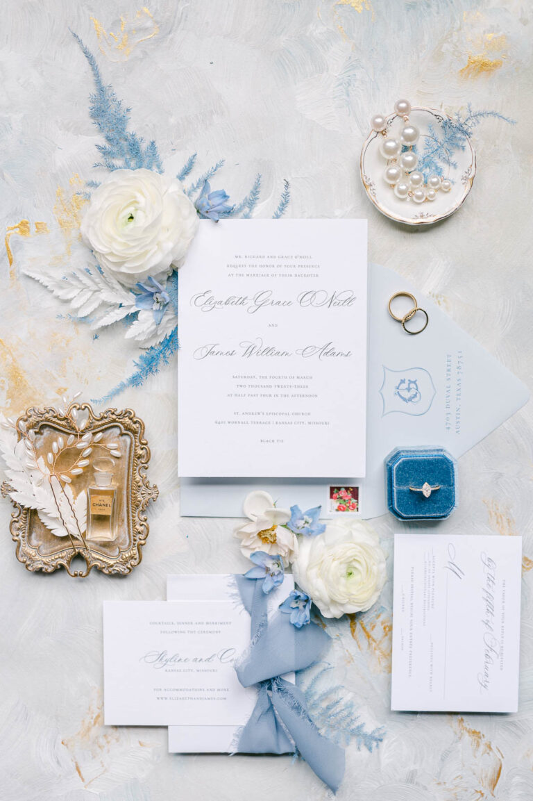 flatlay photo of a wedding invitation suite in blue, white and gold